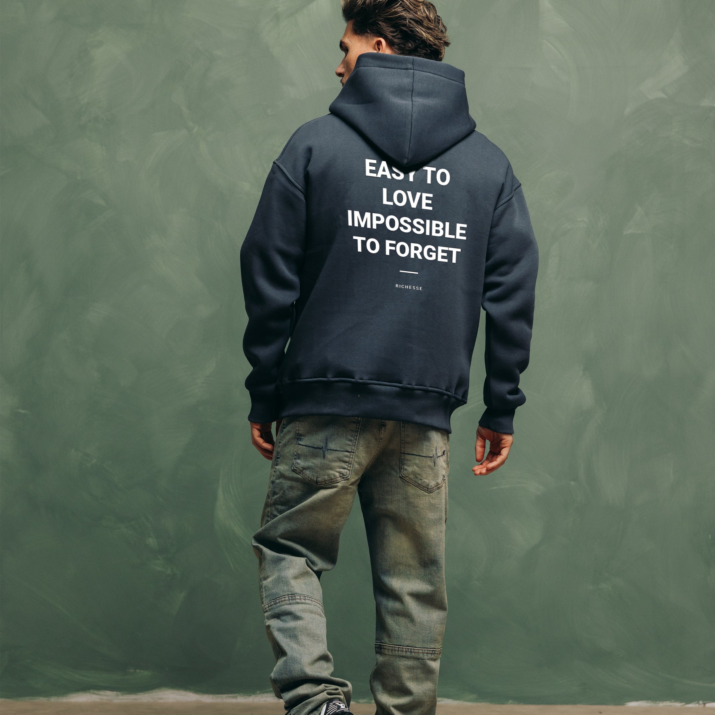 Model van achteren in de Unforgettable Hoodie met de print Easy to love, impossible to forget