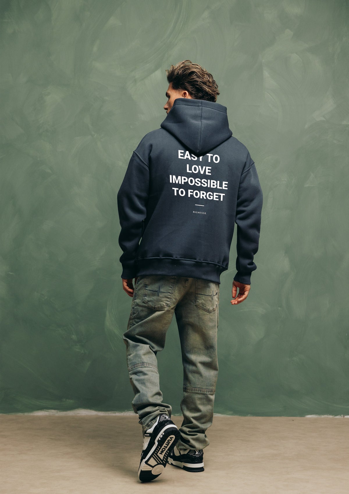 Model van achteren in de Unforgettable Hoodie met de print Easy to love, impossible to forget