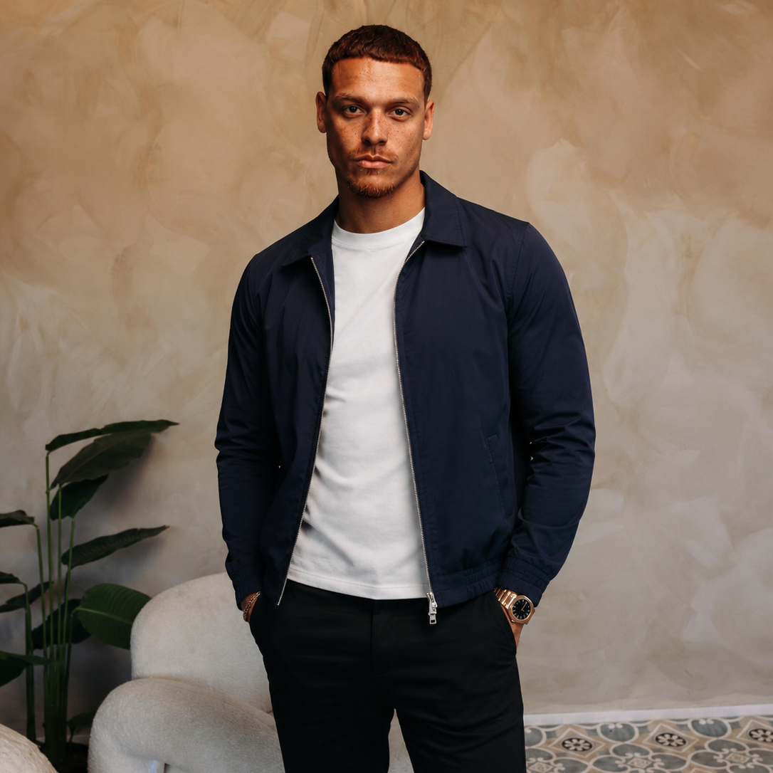 Model in de navy Smart Jacket over een wit T-shirt met een zwarte broek