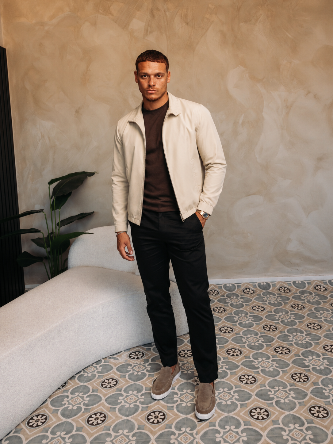 Model in de creme Smart Jacket over een bruin T-shirt met een zwarte broek